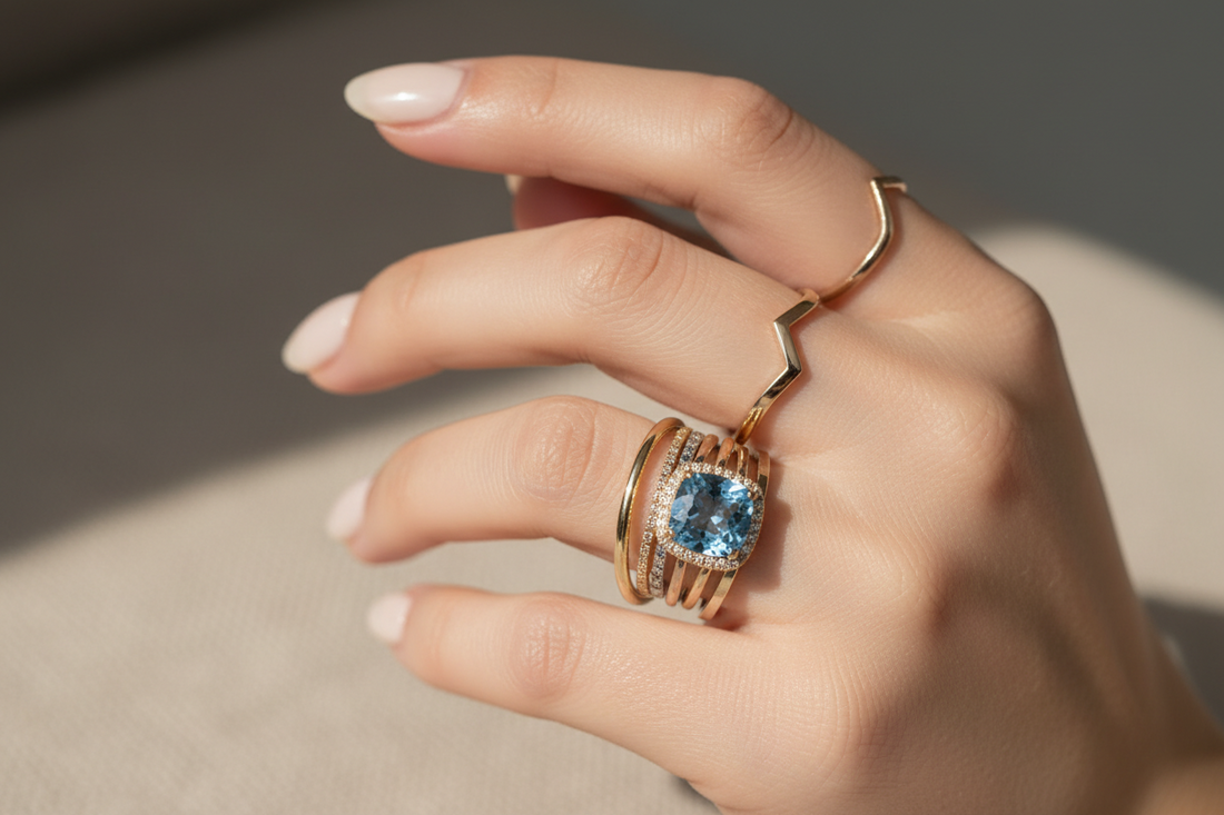 Elegant hand showcasing balanced ring layering with mixed metals, gemstones, and minimalist stacking bands.