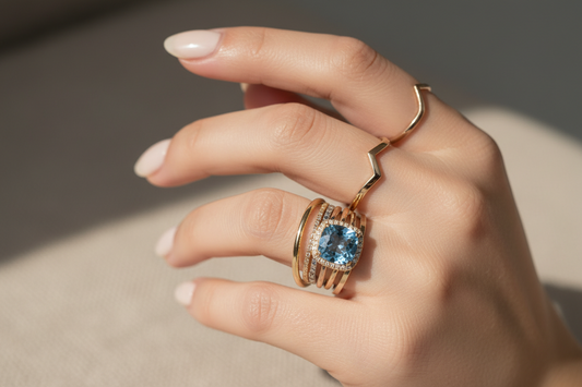 Elegant hand showcasing balanced ring layering with mixed metals, gemstones, and minimalist stacking bands.