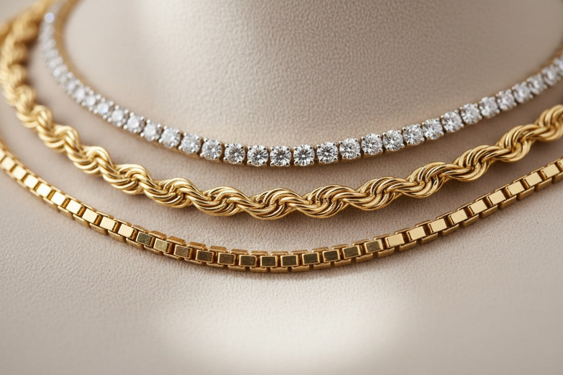 A stylish layered stack of tennis, rope, and box chains displayed on a model or mannequin. The chains vary in length, texture, and thickness, creating a balanced cascading look that highlights shine, dimension, and modern elegance.
